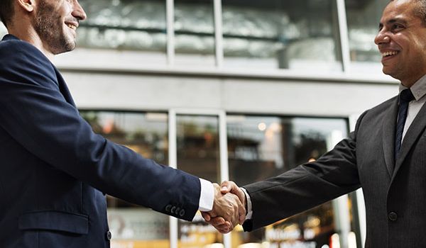 Real estate specialists making a handshake to materialize their strategic partnership